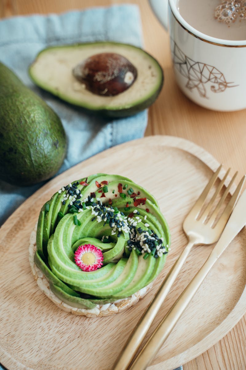 Green and Brown Pastry on Brown Wooden Round Plate Beside Silver Fork