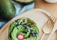 Green and Brown Pastry on Brown Wooden Round Plate Beside Silver Fork